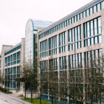 Budynek handlowy z szklanymi oknami w zimowej scenerii, przedstawiający architekturę miejską.