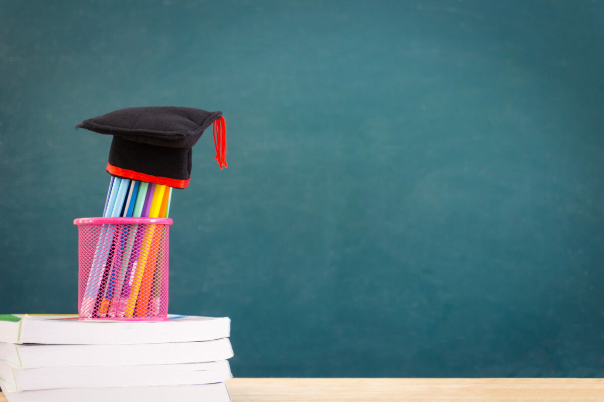 Stos książek na biurku, symbolizujący poszukiwanie pracy i rozwój zawodowy. CV studenckie